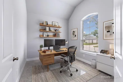 a view of a workspace with furniture and a window
