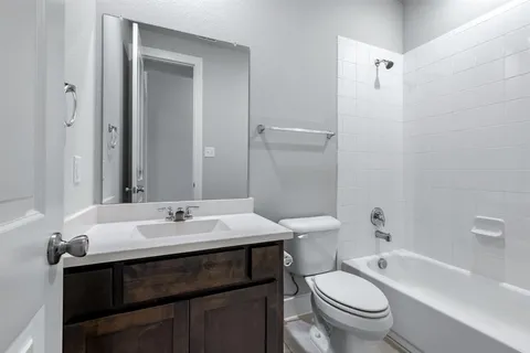 a bathroom with a sink a toilet a mirror and shower