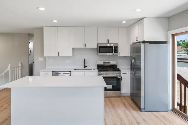 a kitchen with stainless steel appliances a refrigerator stove microwave and cabinets