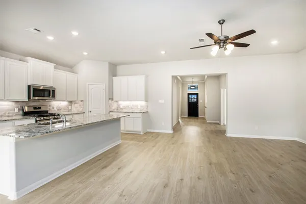 a view of a kitchen with a sink stainless steel appliances and cabinets
