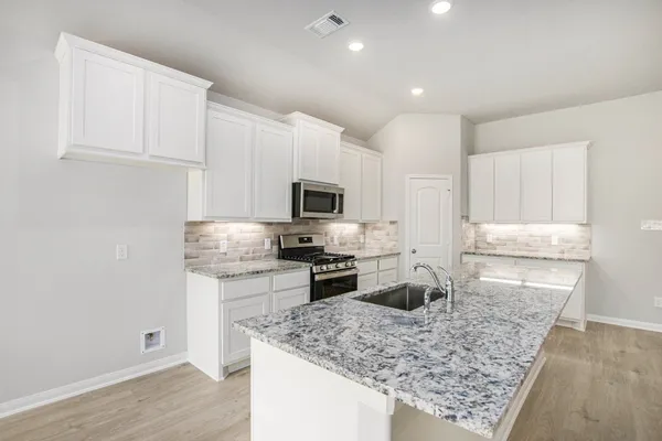 a kitchen with stainless steel appliances granite countertop a sink stove and refrigerator