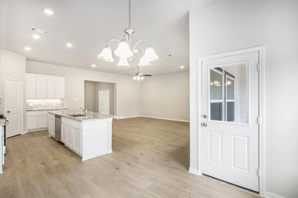 a open kitchen with a sink dishwasher a stove and a refrigerator with wooden floor