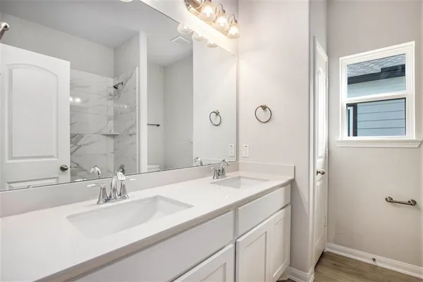 a bathroom with a sink double vanity and a mirror