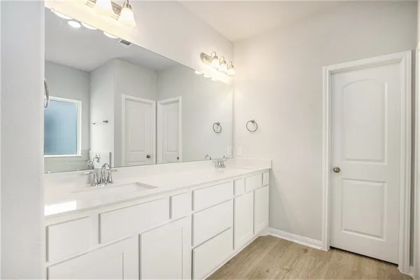 a bathroom with a double vanity sink and a mirror