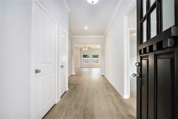 a view of a hallway with wooden floor and staircase