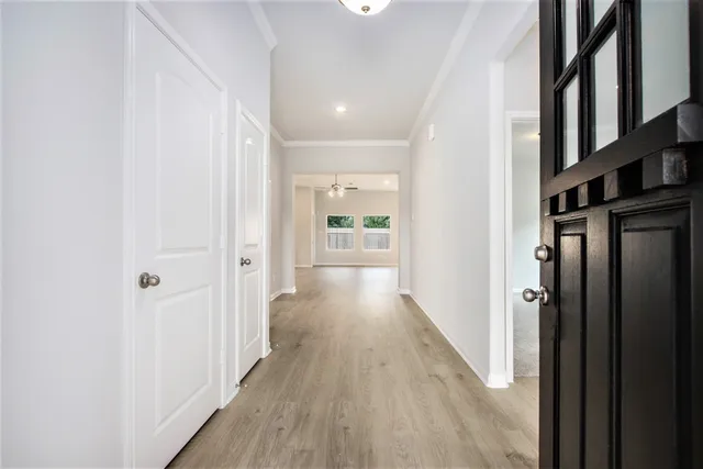 a view of a hallway with wooden floor and staircase