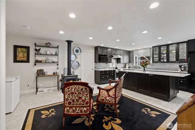 a living room with stainless steel appliances lots of furniture and kitchen view
