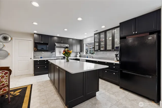 a kitchen with kitchen island granite countertop stainless steel appliances a sink stove and refrigerator
