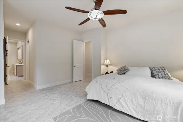 a bedroom with a bed and a ceiling fan