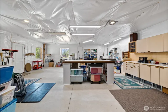 a kitchen with stainless steel appliances kitchen island granite countertop a refrigerator oven a sink dishwasher and white cabinets with wooden floor