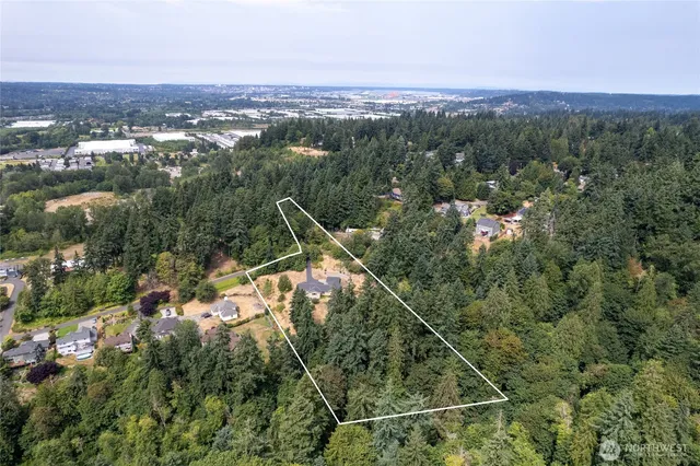 an aerial view of a residential houses covered in trees