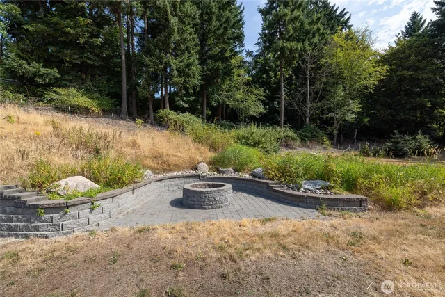 a view of swimming pool with lawn chairs and plants