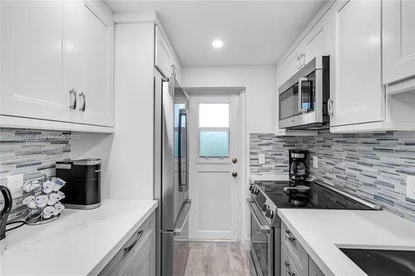a kitchen with stainless steel appliances a sink stove and refrigerator