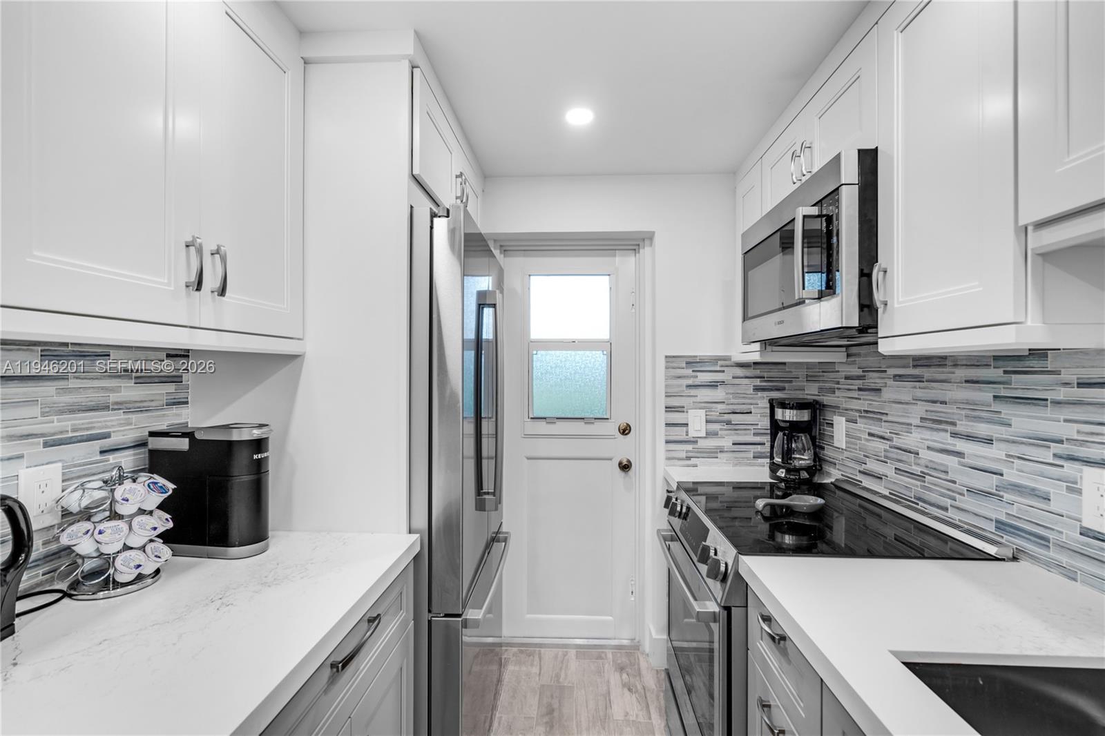 4502 North Federal Highway, Unit 167H Lighthouse Point, FL 33064 - Photo 11 of 31 a kitchen with stainless steel appliances a sink stove and refrigerator