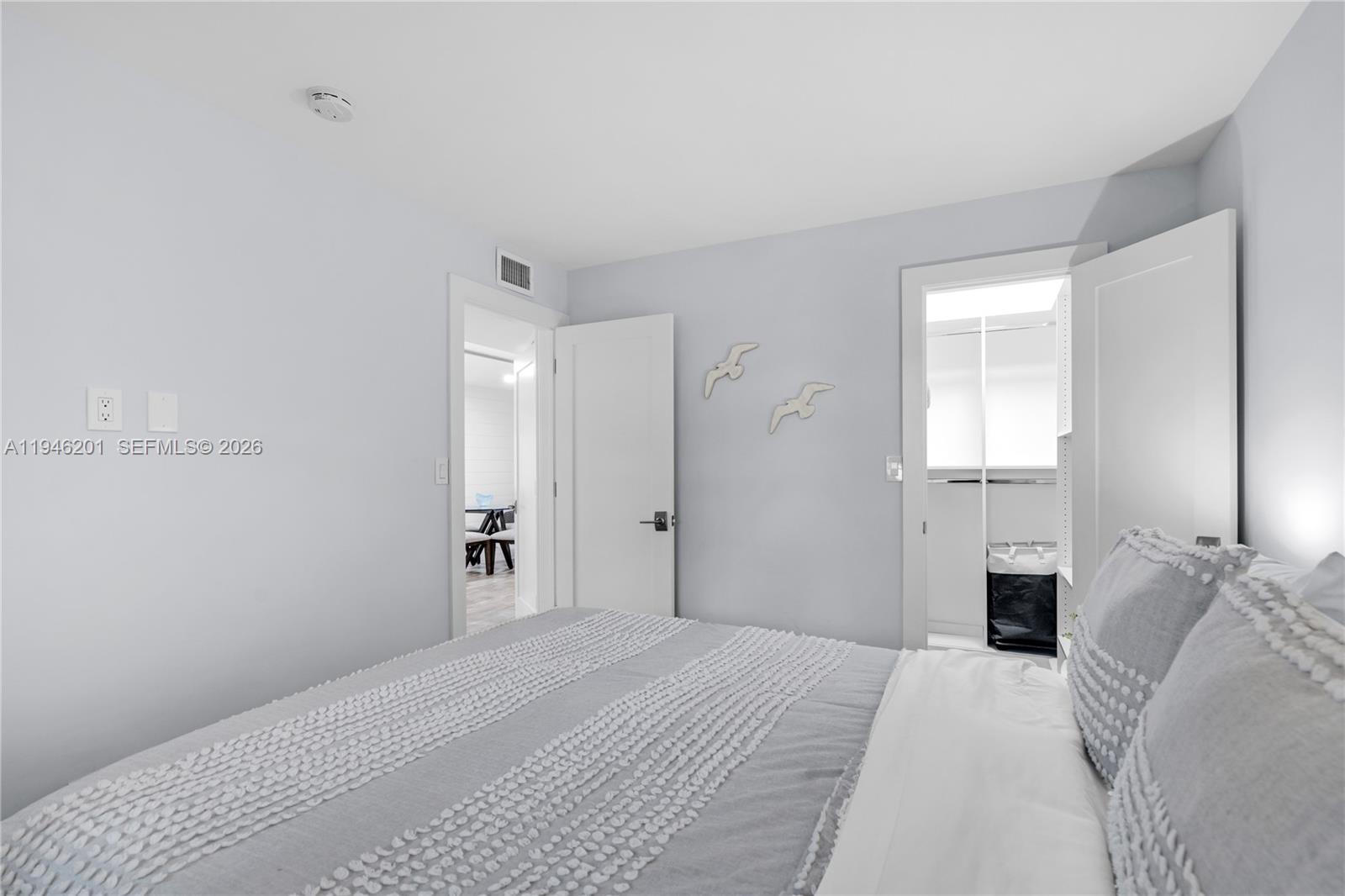 4502 North Federal Highway, Unit 167H Lighthouse Point, FL 33064 - Photo 17 of 31 a bedroom with a bed and a chandelier