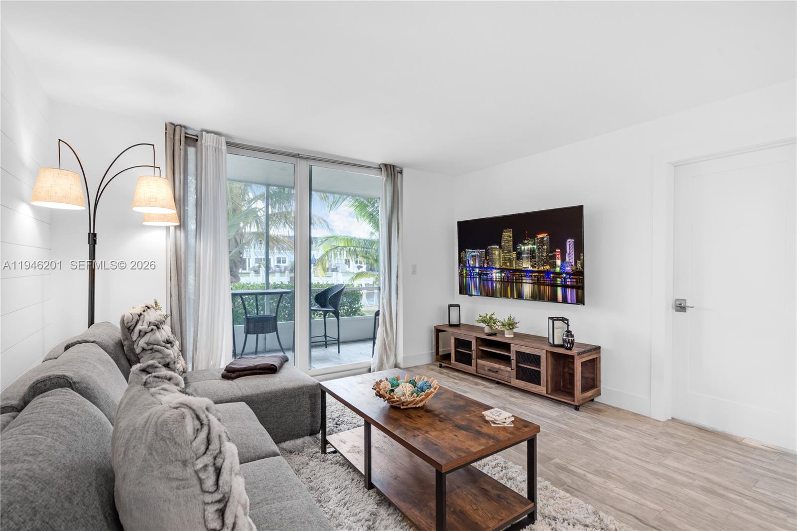 4502 North Federal Highway, Unit 167H Lighthouse Point, FL 33064 - Photo 7 of 31 a living room with furniture a flat screen tv and a floor to ceiling window