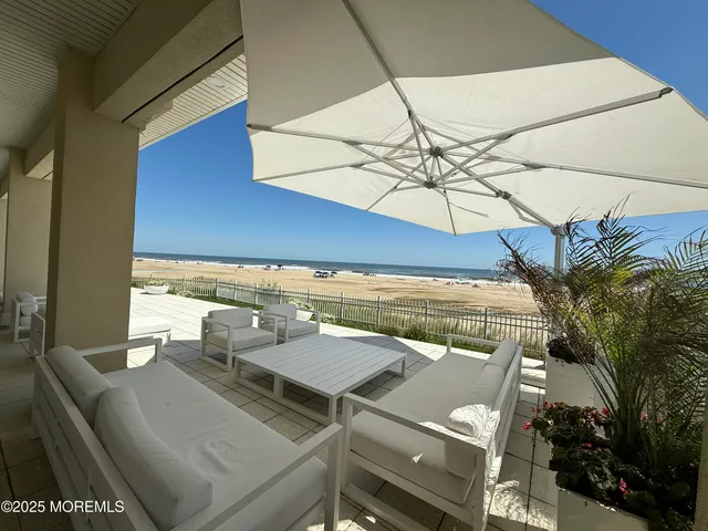 a roof deck with a table and chairs under an umbrella