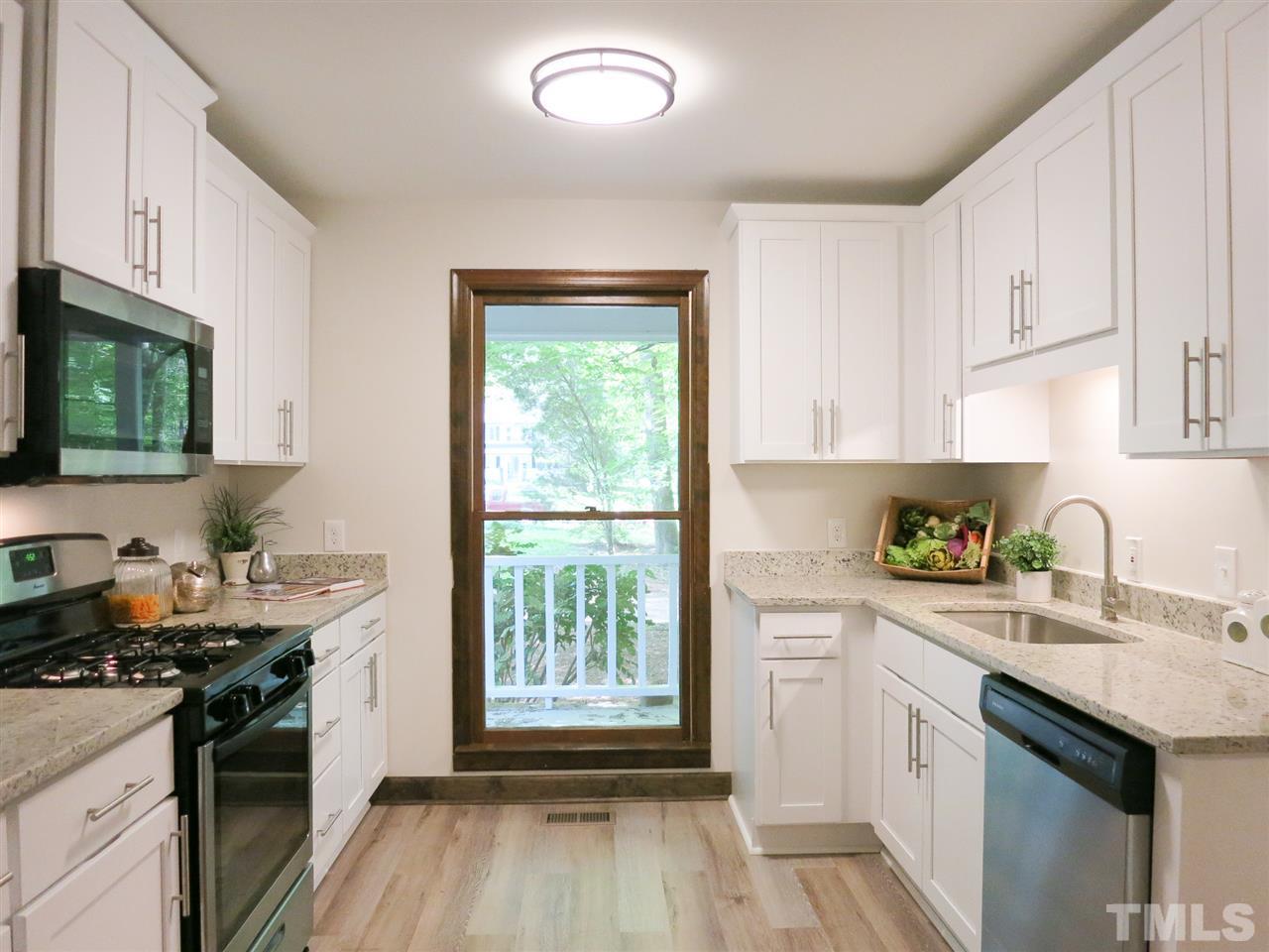 809 Ivanhoe Drive Raleigh, NC 27615 - Photo 12 of 30 Brand NEW Kitchen has tall white cabinets, granite counters, SS appls (gas range/MW/DW), LVP flr, hardware & faucet.
