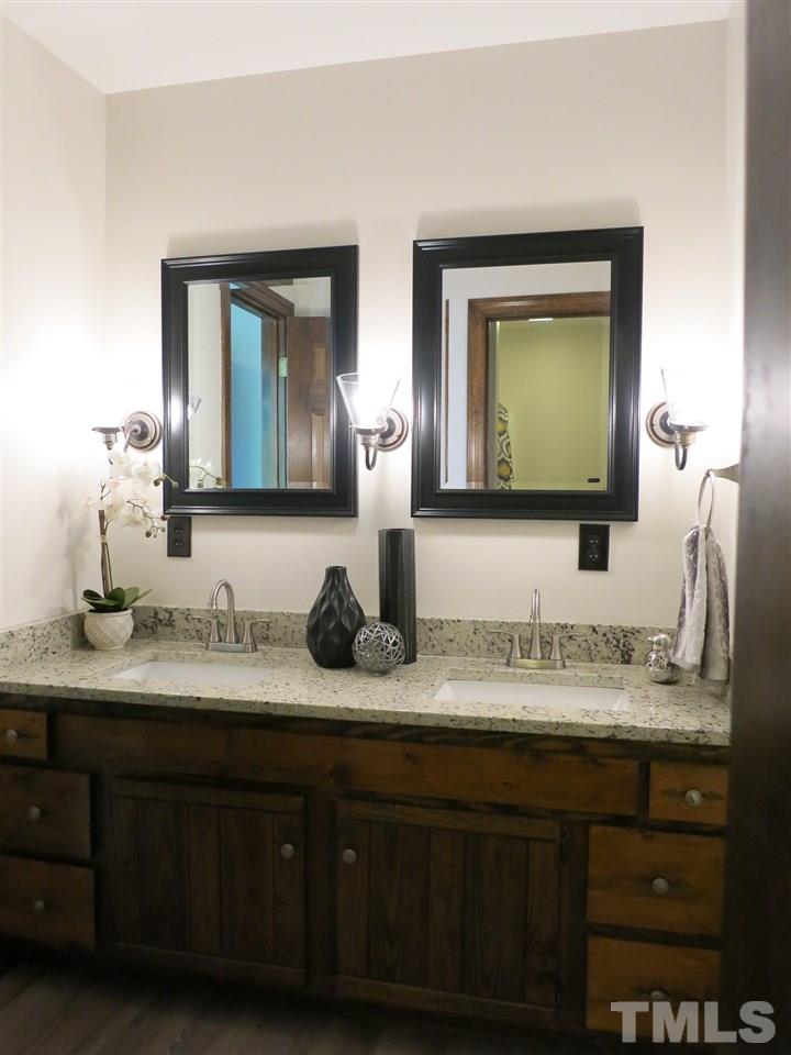809 Ivanhoe Drive Raleigh, NC 27615 - Photo 21 of 30 Master Bath w/LVP flooring, new hardware & lighting and granite counter top w/double sinks.
