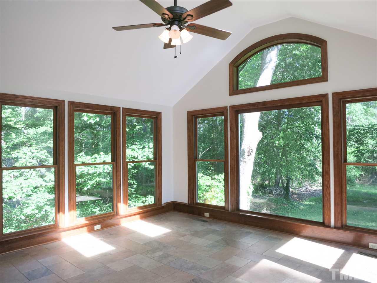 809 Ivanhoe Drive Raleigh, NC 27615 - Photo 7 of 30 Vaulted Sun Rm w/skylights, CF & stone tile floor steps out to Deck.