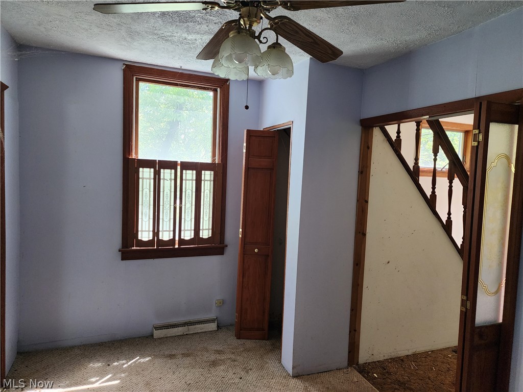 12199 Webster Road Strongsville, OH 44136 - Photo 5 of 10 Spare room with plenty of natural light, ceiling fan, and a textured ceiling