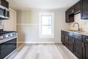 a kitchen with stainless steel appliances granite countertop a stove a sink and a microwave