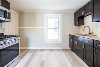 a kitchen with stainless steel appliances granite countertop a stove a sink and a microwave