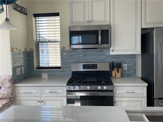a kitchen with granite countertop white cabinets and appliances