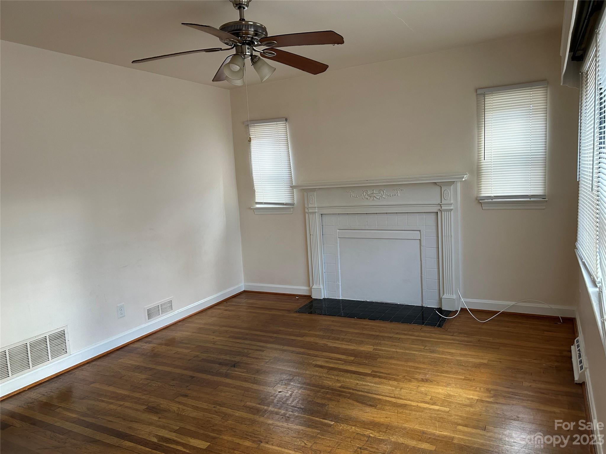 2012 Gilbert Street Charlotte, NC 28216 - Photo 3 of 13 a view of an empty room with wooden floor and a window
