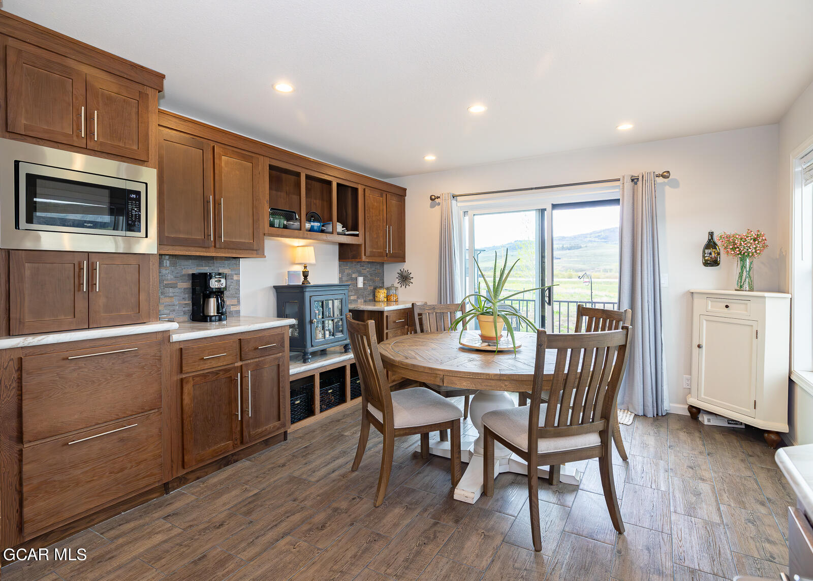 551 Summit Trail, Unit 34 Granby, CO 80446 - Photo 6 of 35 a kitchen with stainless steel appliances granite countertop a kitchen island hardwood floor sink stove dining table and chairs