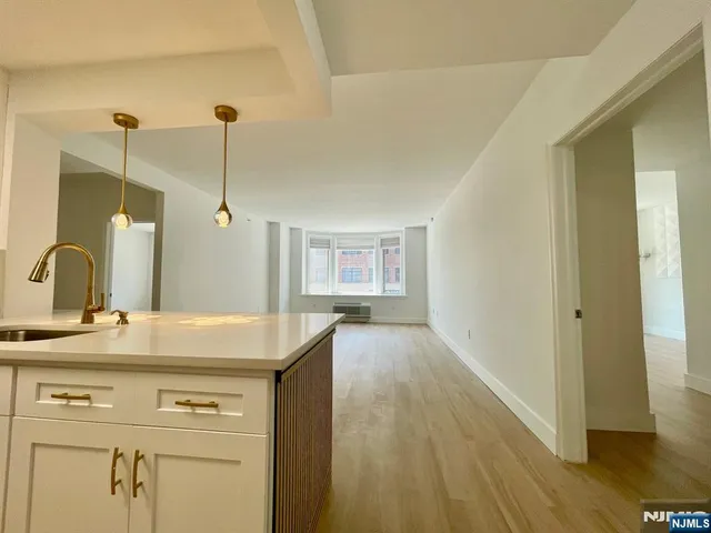 a kitchen with a sink a stove and a wooden floor