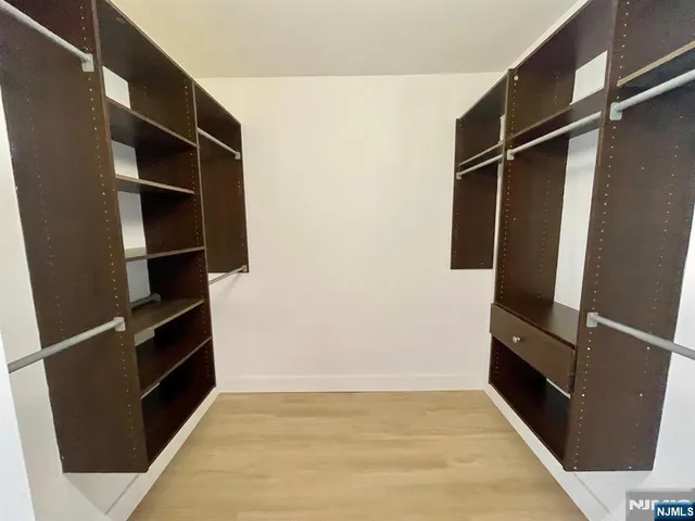 a view of walk in closet with empty racks