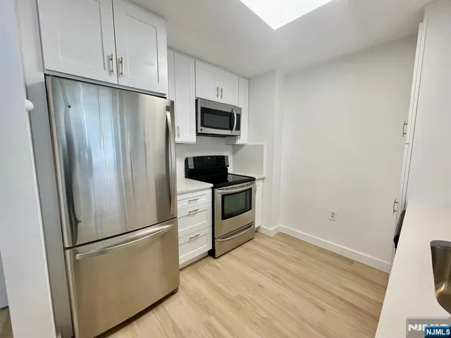 a kitchen with stainless steel appliances a refrigerator stove and microwave