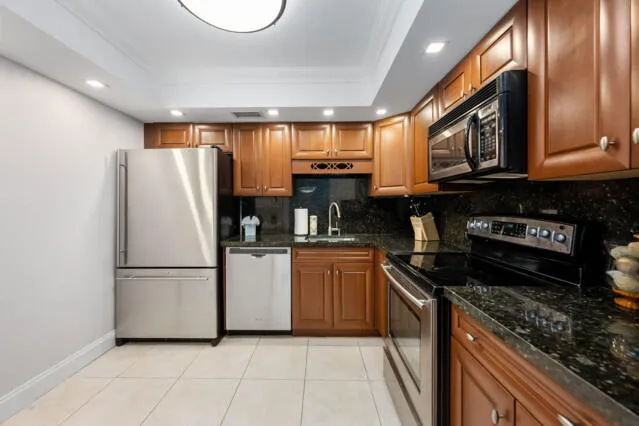 a kitchen with stainless steel appliances granite countertop a stove sink microwave and cabinets