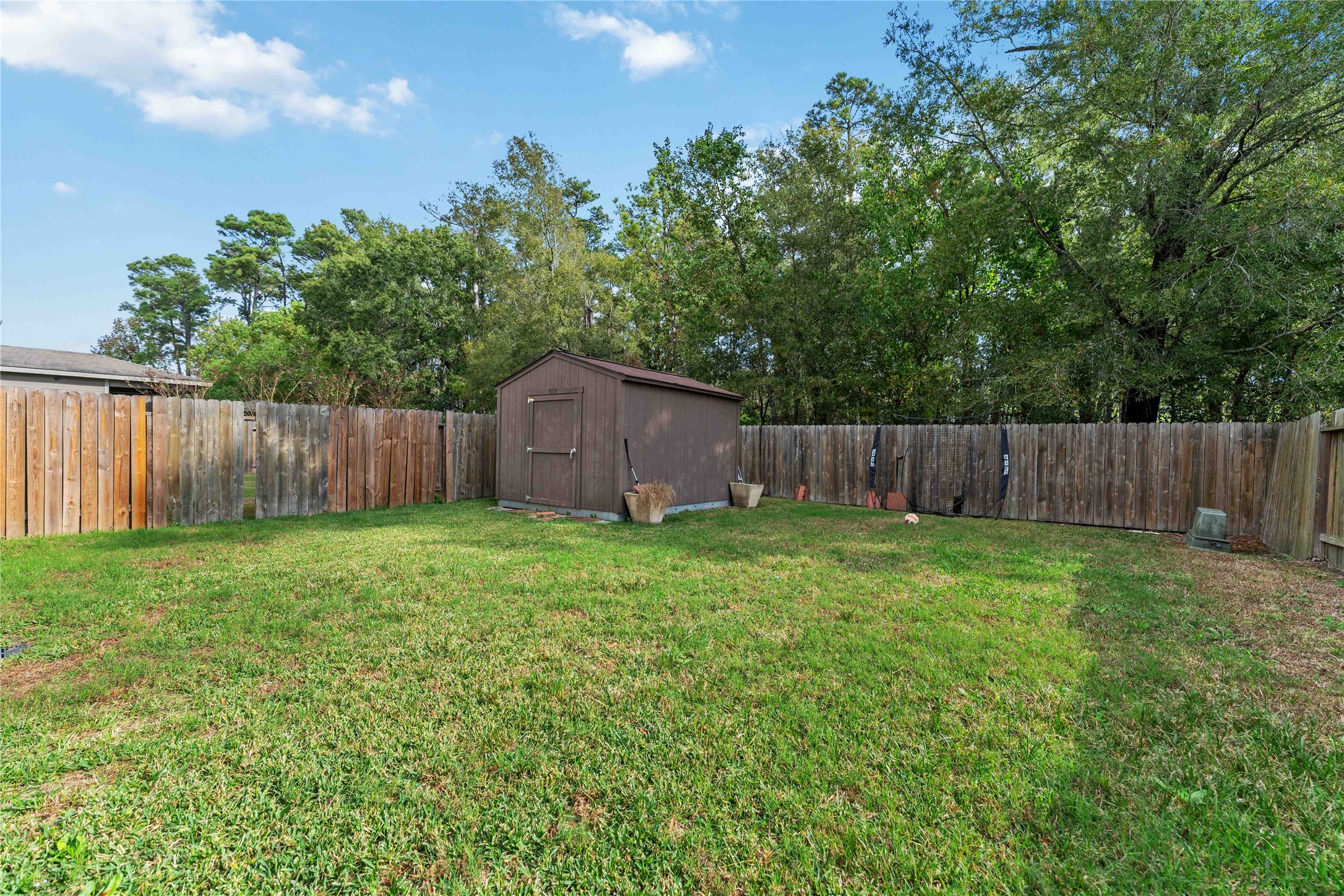 10114 Orchid Spring Lane Houston, TX 77044 - Photo 22 of 22 a view of a backyard with large trees and wooden fence