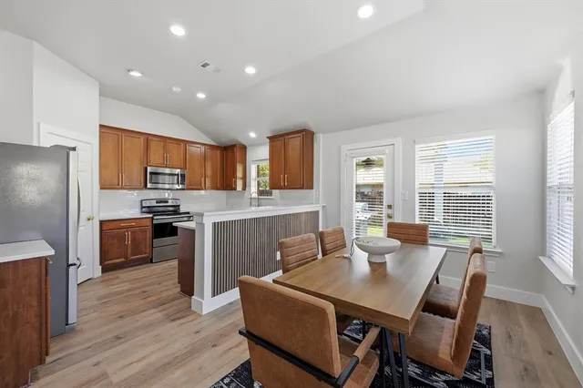 a kitchen with a table chairs refrigerator and cabinets
