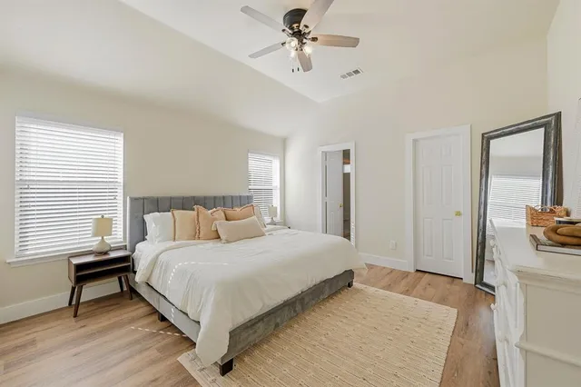 a bedroom with a bed wooden floor and a table