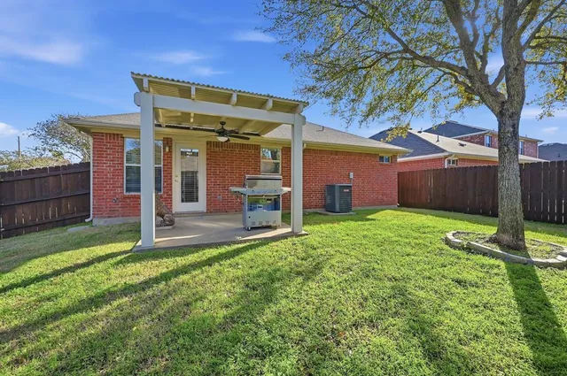 a view of a house with backyard and a tree