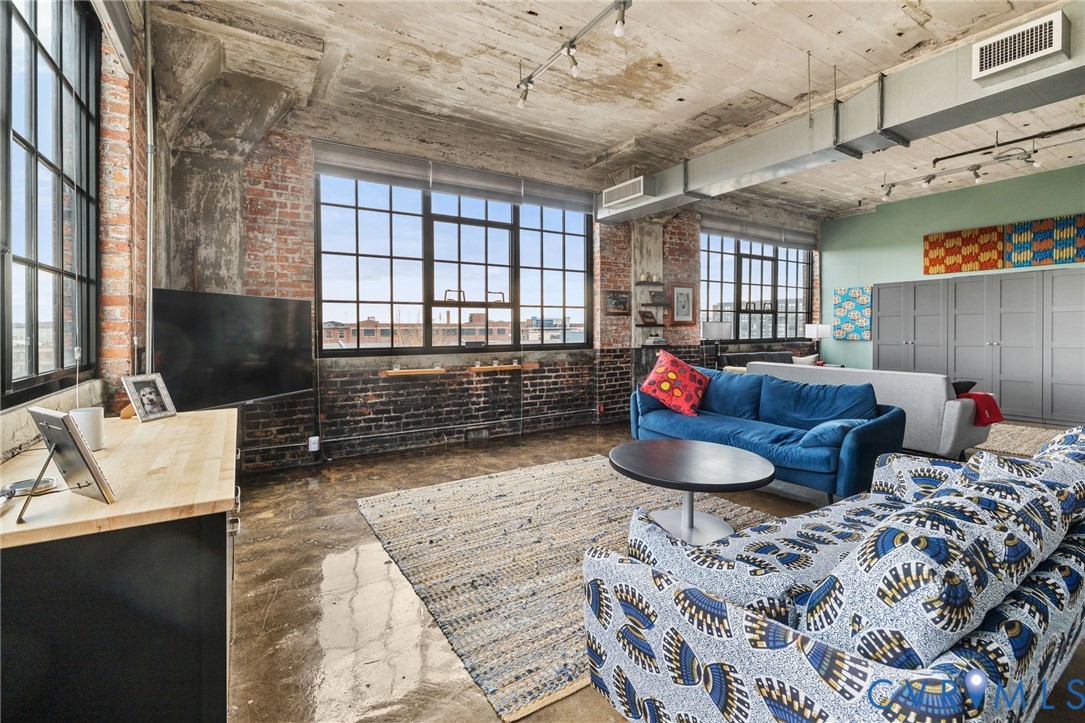 201 Hull Street, Unit U44 Richmond, VA 23224 - Photo 12 of 30 a living room with furniture a flat screen tv and a large window