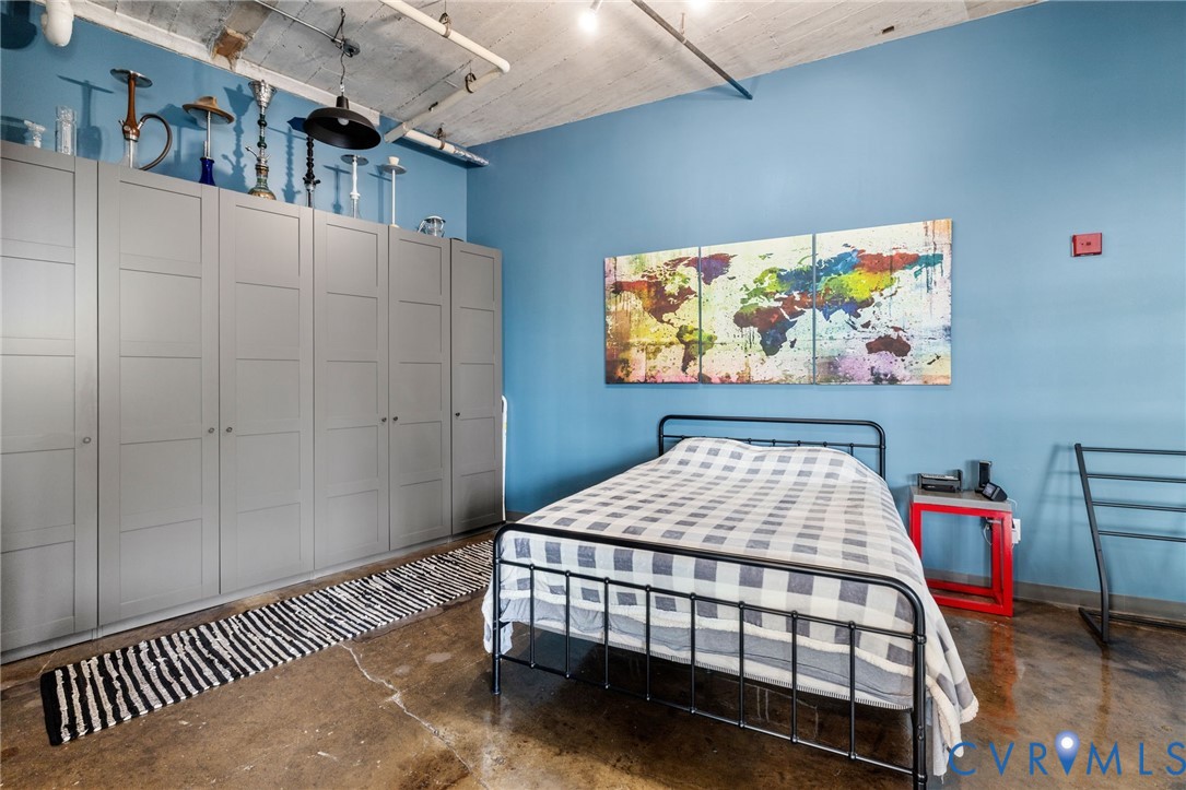 201 Hull Street, Unit U44 Richmond, VA 23224 - Photo 15 of 30 a bedroom with a bed a wall painting and a book shelf