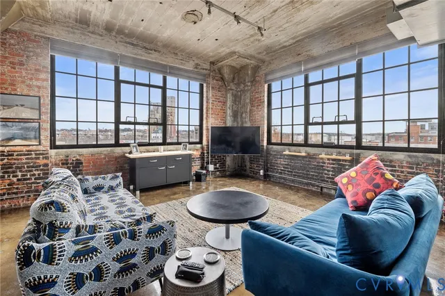 a living room with furniture a flat screen tv and a large window