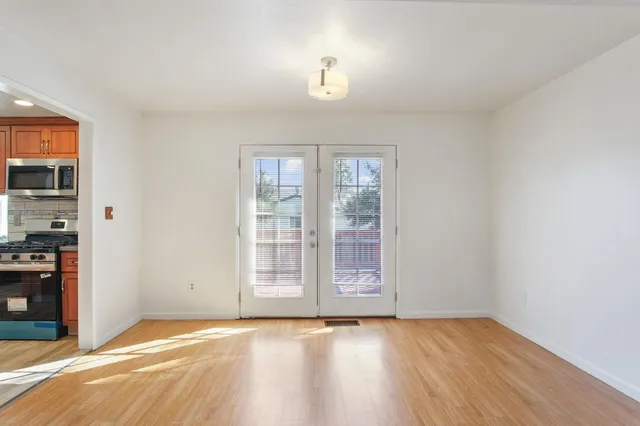 an empty room with wooden floor and windows