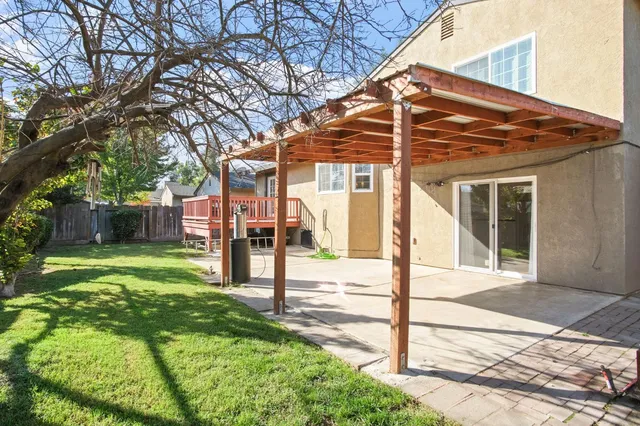 a view of a house with backyard and a tree