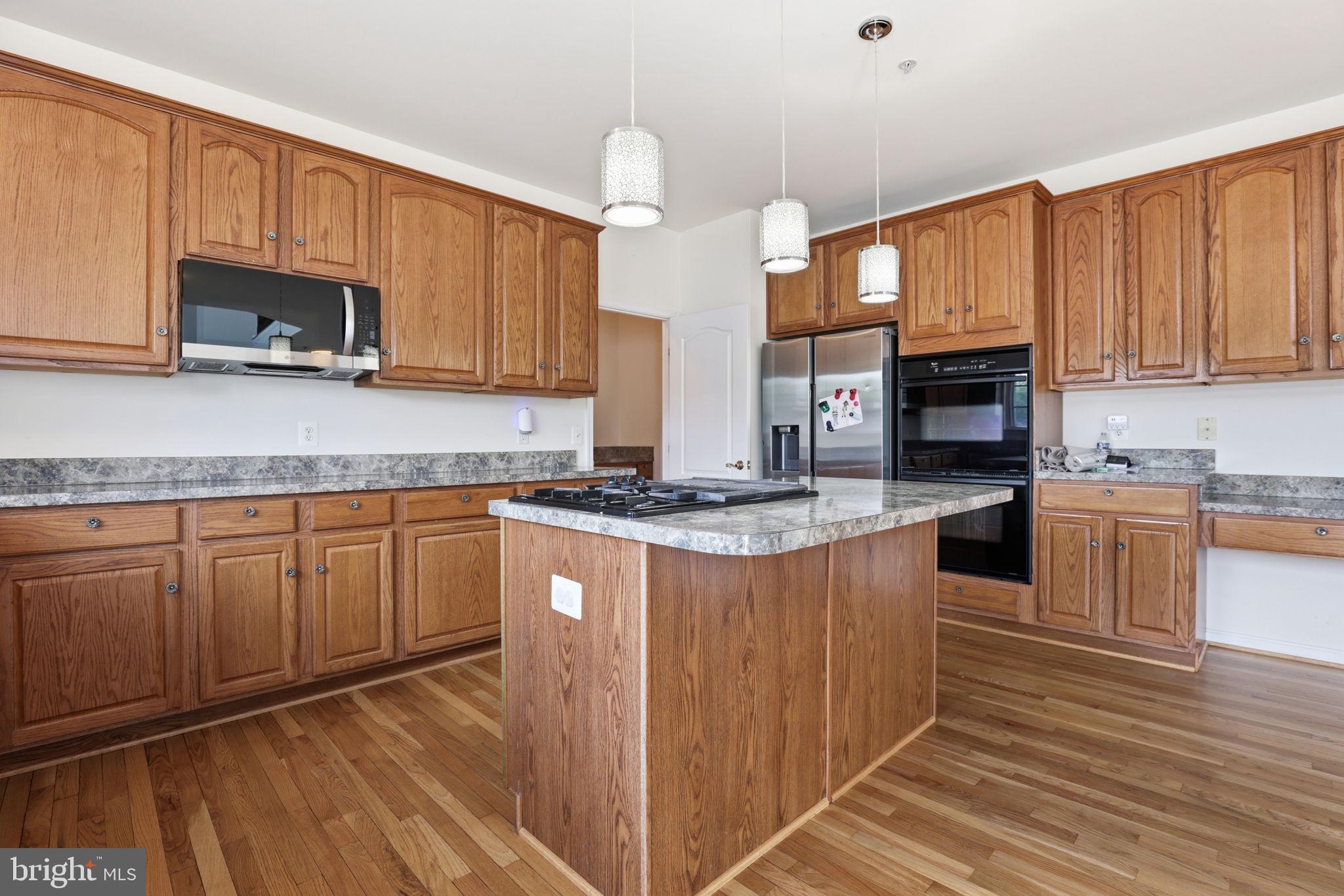 10105 Elgin Circle Bowie, MD 20721 - Photo 11 of 32 a kitchen with stainless steel appliances granite countertop a stove a sink dishwasher and a microwave oven with wooden cabinets