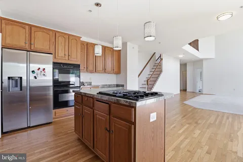 a kitchen with granite countertop a stove and a refrigerator