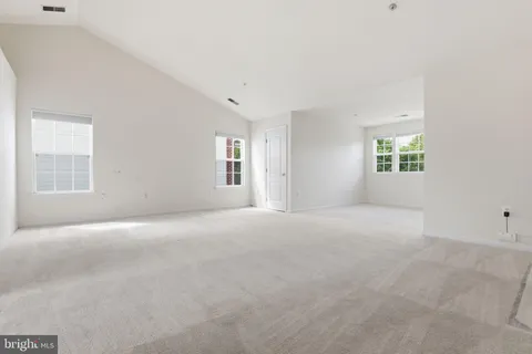 a view of a big room with windows and chandelier fan