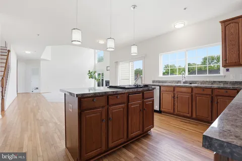 a kitchen with a sink a window and wooden cabinets