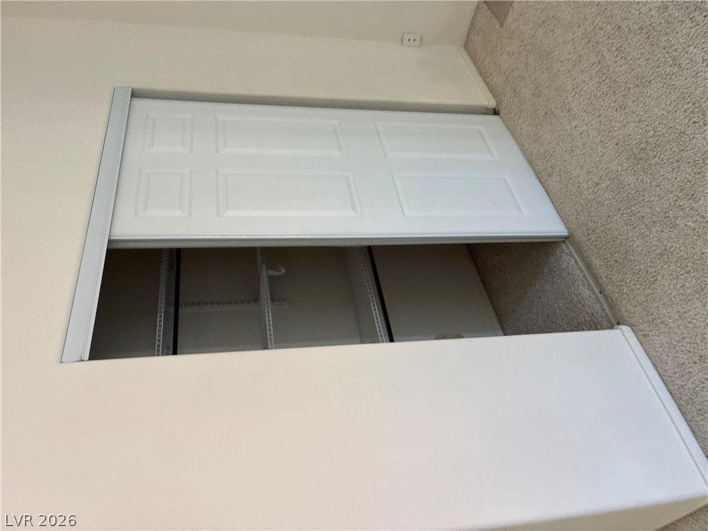 5272 Island Chain Road Las Vegas, NV 89118 - Photo 28 of 39 Smart storage solution features an attic access door blending seamlessly with the carpeted floor.