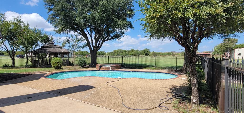 211 Bayne Road Haslet, TX 76052 - Photo 5 of 18 a view of swimming pool with a table and chairs under an umbrella