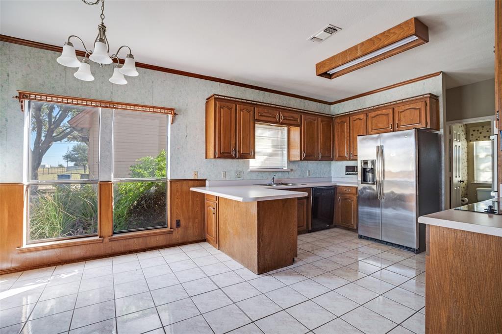 211 Bayne Road Haslet, TX 76052 - Photo 7 of 18 a kitchen with stainless steel appliances granite countertop a refrigerator a sink a stove a washer dryer and a chandelier